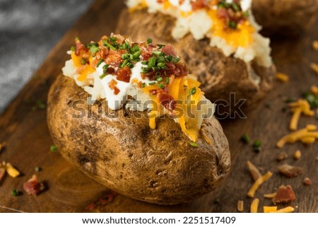 Homemade Loaded Baked Potatoes with Bacon Cheddar and Sour Cream Royalty-Free Stock Photo #2251517409