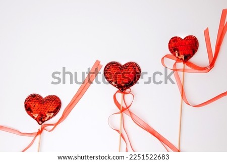 Red hearts in sequins on a white background. Valentine's Day background. Flat lay