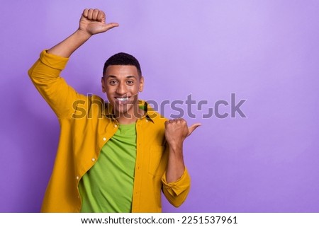 Photo portrait of attractive young male point energetic empty space dressed stylish yellow outfit isolated on violet color background