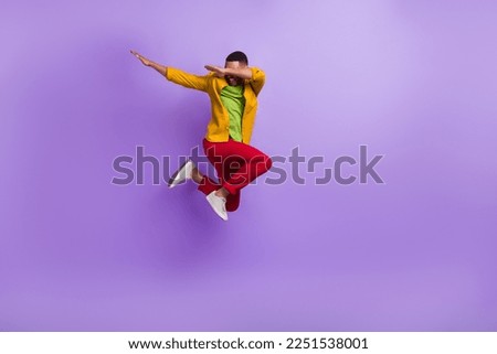 Full length portrait of carefree overjoyed person jumping arms dabbing isolated on purple color background Royalty-Free Stock Photo #2251538001