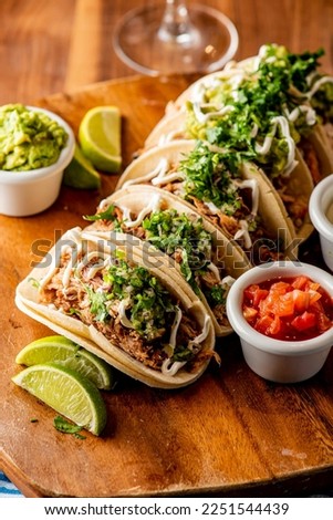 Tacos. Crispy flour and corn tortillas filled with sausage, bacon, beef, cheese, sour cream, salsa and guacamole and served with rice and beans. Classic Tex-Mex or Mexican restaurant entrée favorite. Royalty-Free Stock Photo #2251544439