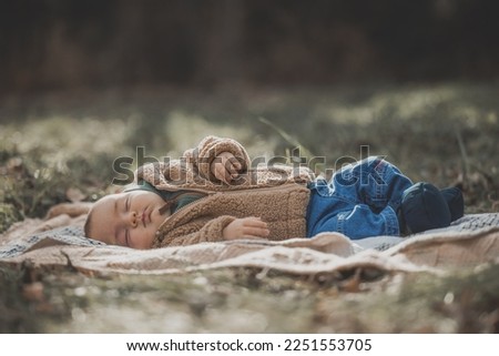 Beautiful New born fall photo shoot in forest. Baby with jeans fluffy sweater and booties