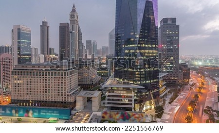 Dubai International Financial district night to day transition . Aerial view of business office towers before sunrise. Illuminated skyscrapers with hotels near downtown