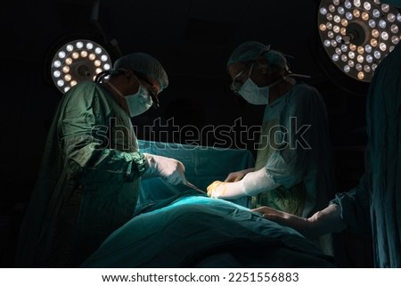 Doctors are performing the surgery. Doctors in green uniforms in the operating room. They do endoscopic surgery. Royalty-Free Stock Photo #2251556883