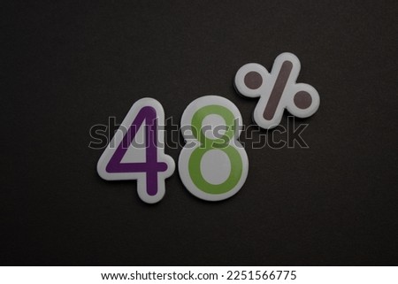 colorful lettering 48 percent over a black background.