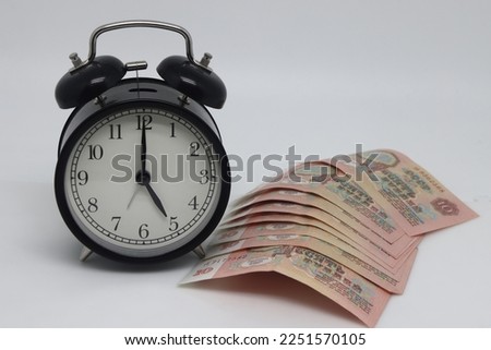 Alarm clock and banknotes on white background. Time is money.. Old banknotes of the former Soviet Union. USSR - rubles