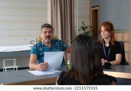 patient and doctor, Doctor examining patient's lab results. Doctor's assistant next to him treats the patient with a smiling face