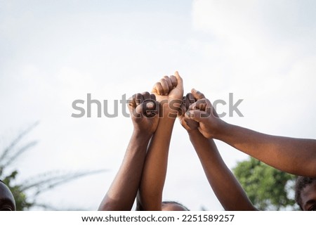 Four fists of African people united in sky, photo with copy space above Royalty-Free Stock Photo #2251589257