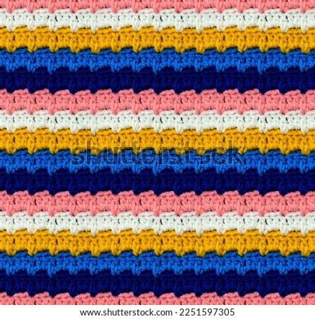 Seamless knitted pattern crocheted from bright acrylic yarn. Pixel style. Ethnic color motifs.