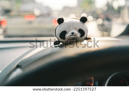 Panda doll on a car's dashboard