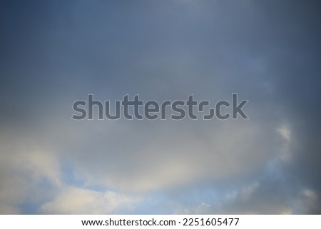 rays of the sun through cirrus clouds against a blue sky, white rainy clouds against a blue sky illuminated by the rays of the sun	
