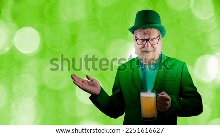Funny bearded man celebrates St. Patrick's Day and holds mugs of beer
