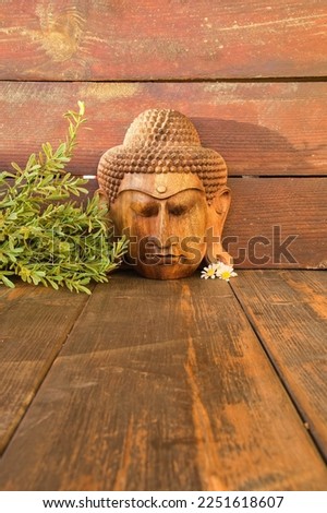Buddha image on rustic wooden boards background. Concept of meditation, relaxation and calm. Spa atmosphere