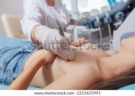 Young woman getting breast examination by her gynecologist ultrasound scanning Royalty-Free Stock Photo #2251625991