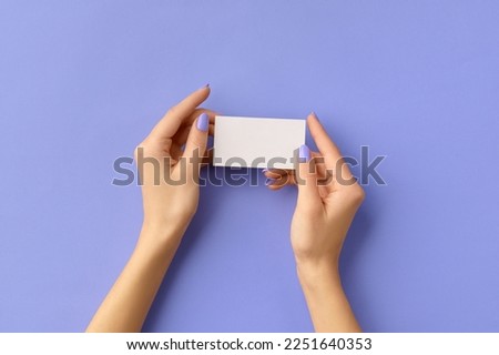 Womans hands holding business card on purple background. Business work template mockup
