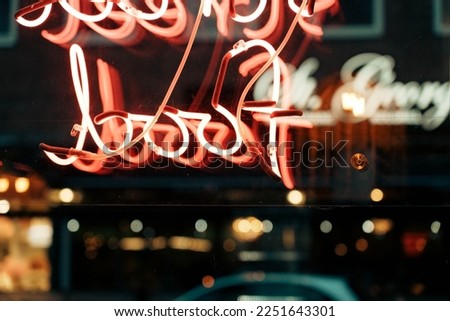 Colored neon lights. Signs with neon tubes on shop windows in the evening.