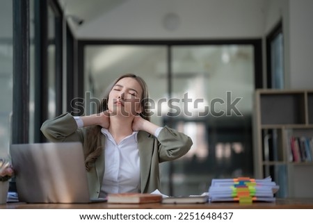 Portrait of Asian businesswoman with shoulder pain and backache office background, Female working hard, office syndrome concept.
