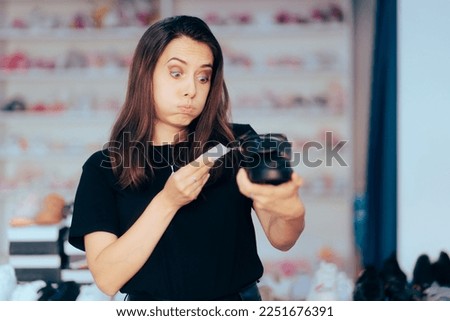 
Stressed Client Checking a Price Tag in a Shoe Store. Funny customer looking for bigger discount for sandals 
 Royalty-Free Stock Photo #2251676391