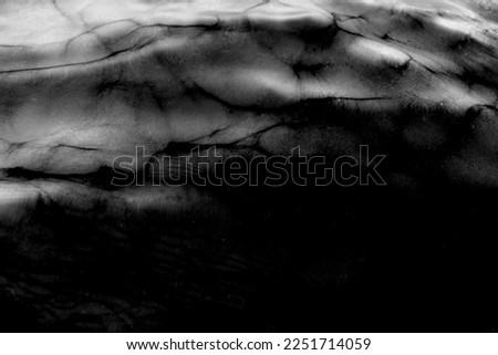 Black and white photo of the texture of the water surface of the movement of the waves with shadows in the dark. Abstraction. Background