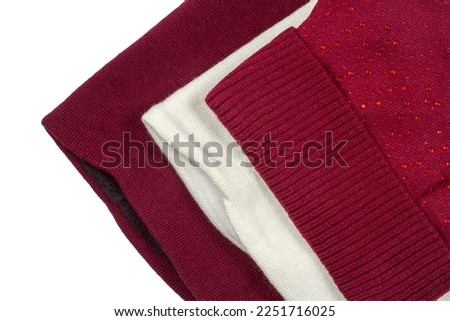 Knitted woollen clothing on a white background. Casual woollen clothing.