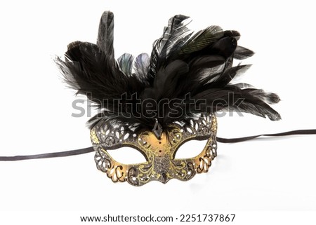 Carnival Venetian mask golden color with black feather decoration isolated on white background