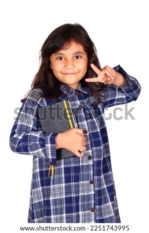 Cute Asian little girl holding books on white background