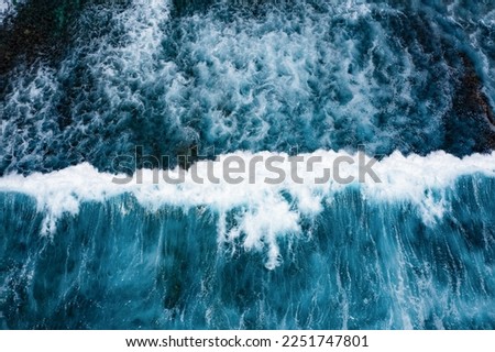 Stunning aerial view of some ocean waves breaking on a blue sea. Crushing waves, ocean waves relaxation. Bali, Indonesia.