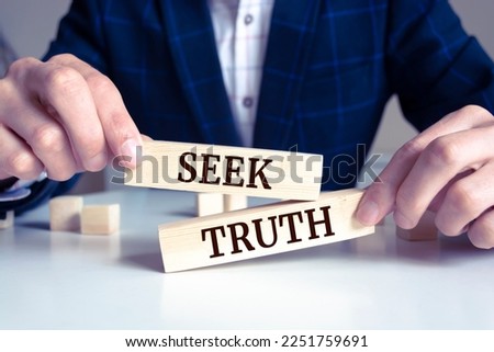 Close up on businessman holding a wooden block with "Seek Truth" message