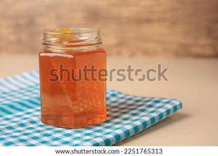 Jar with honey and combs on light table, space for text