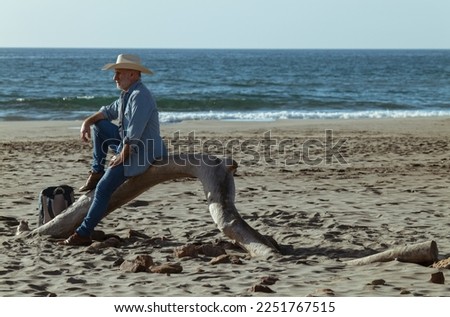 Adult man in cowboy hat on beach
