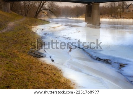 For Gauja, the ice has frozen along the edge of the river. The end of the winter month. Selective focus soft focus.