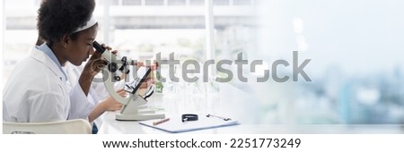 African American girl scientists researching through microscope in the laboratory. Scientific experiment. Early development of children Royalty-Free Stock Photo #2251773249