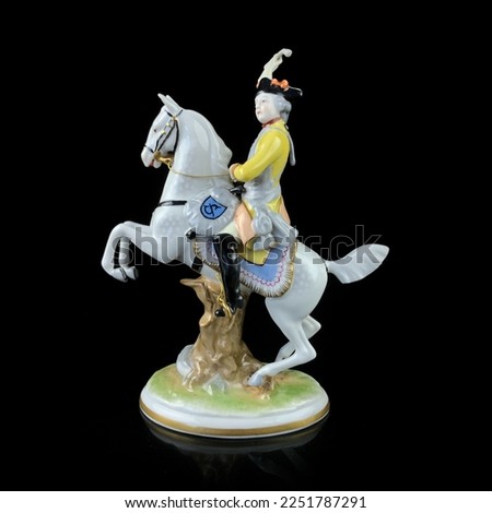 Ceramic figurine of a male commander on a horse on a black background. porcelain figure of a general