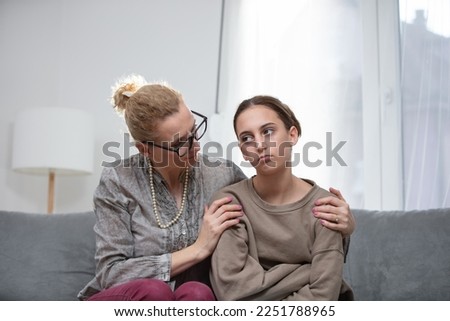 Mother comforting troubled teenager daughter at home. Royalty-Free Stock Photo #2251788965
