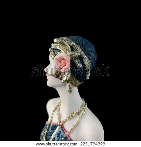 Ceramic figurine of a fantastic woman in a blue dress on a black background. porcelain antique figurine of a woman in retro clothes. close-up