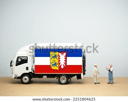 Mini toy at table with white background. Industrial shipping concept. Schleswig-Holstein flag concept,  is the northernmost of the 16 states of Germany.