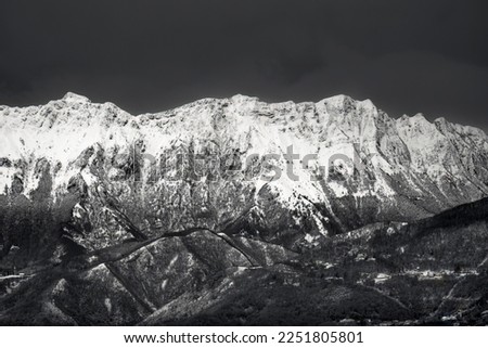 The Julian Alps in winter season. Black and white snowy mountain landscape. View from the Udine city castle, Friuli Venezia Giulia region, Italy. 