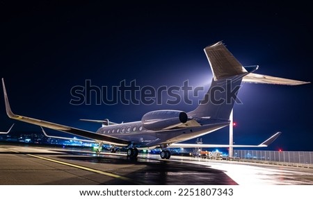 Private jet parked at night, making an elegant aviation background. Business jet is the way to travel for millionairs and successful people. Royalty-Free Stock Photo #2251807343