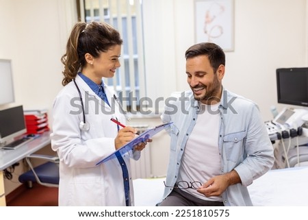 Experienced doctor discussing with patient his private medical file. Young man checking up with his MD, and consulting about the way of his health treatment and health insurance.