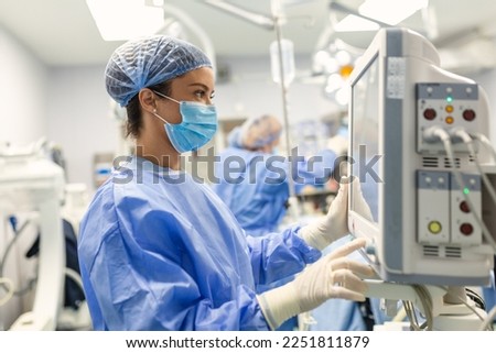 Anesthesiologist keeping track of vital functions of the body during cardiac surgery. Surgeon looking at medical monitor during surgery. Doctor checking monitor for patient health status. Royalty-Free Stock Photo #2251811879