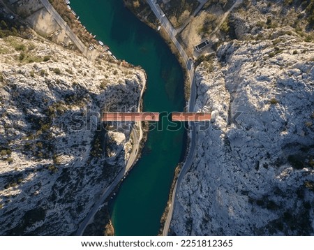 Aerial drone view of Unfinished bridge in Omis, Croatia over the river Cetina. Bridge being built in between the canyon. Industrial and complex construction in the Dalmatia area.  Royalty-Free Stock Photo #2251812365