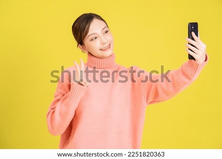 Image of young Asian girl using smartphone on background