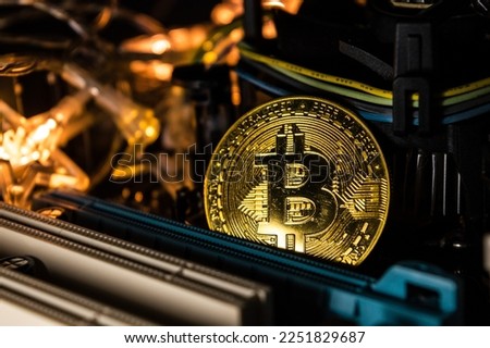 bitcoin coin on computer motherboard with lights.
profitable cryptocurrency to earn money by investing