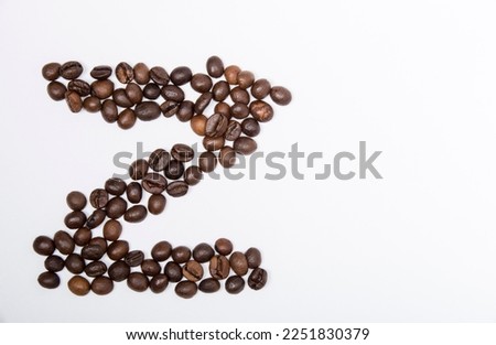 Z is a capital letter of the English alphabet made up of natural roasted coffee beans that lie on a white background. Plenty of space to put text or pictures, top view and studio photography.