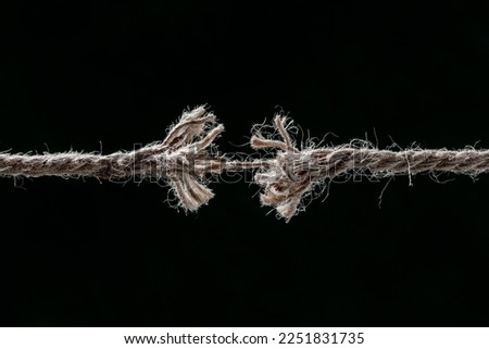 Frayed rope about to break concept for stress, problem, fragility or precarious business situation Royalty-Free Stock Photo #2251831735