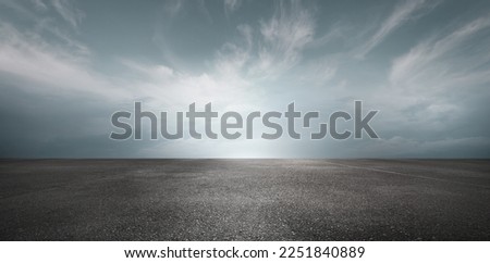 Sky Background Horizon with Dramatic Clouds and Empty Dark Asphalt Street Floor Royalty-Free Stock Photo #2251840889