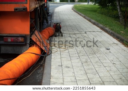 Sewer repair. Orange pipe. Details of works in city. Repair of infrastructure. Royalty-Free Stock Photo #2251855643