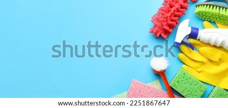 Cleaning supplies on light blue background with space for text