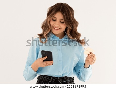 Young brunette woman isolated on white background buying with the mobile with a credit card