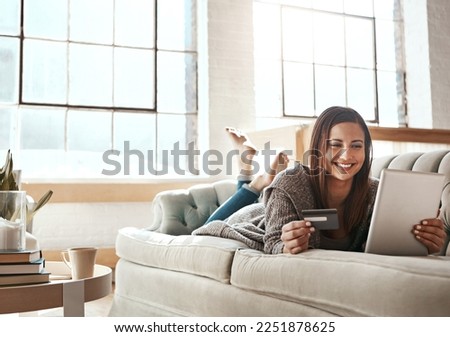 Online shopping, ecommerce and credit card with digital tablet by woman on a sofa, happy and relax. Online banking, debit card and girl checking credit score, savings or membership in a living room Royalty-Free Stock Photo #2251878625
